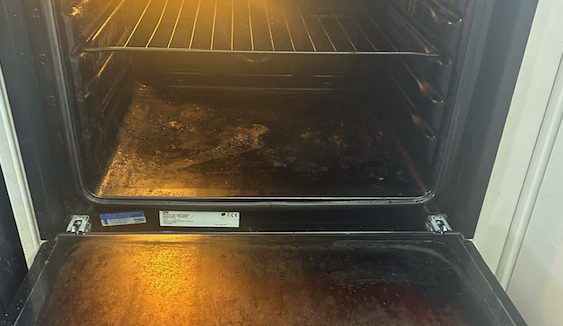 Oven door before cleaning - burnt grease on glass and frame