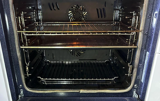 Oven interior before cleaning - showing dirt and residue on racks