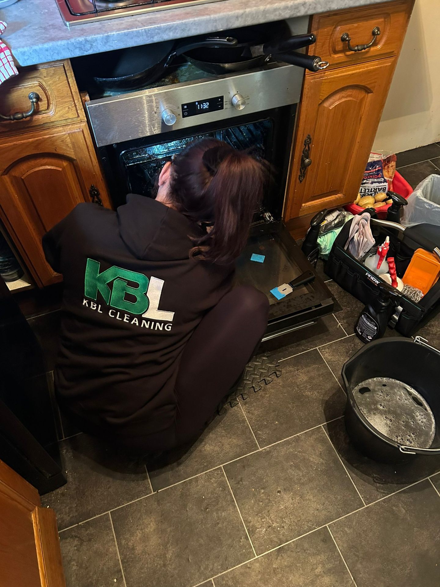 KBL Cleaning technician professionally cleaning an oven in a customer's kitchen