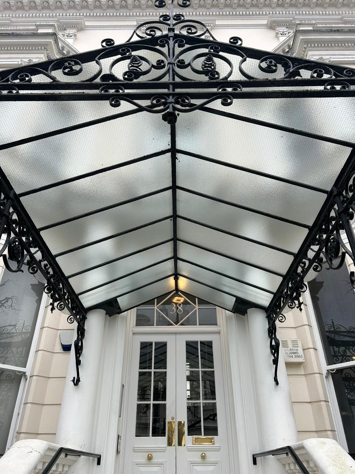 Professional entrance cleaning showing ornate canopy and pristine building facade