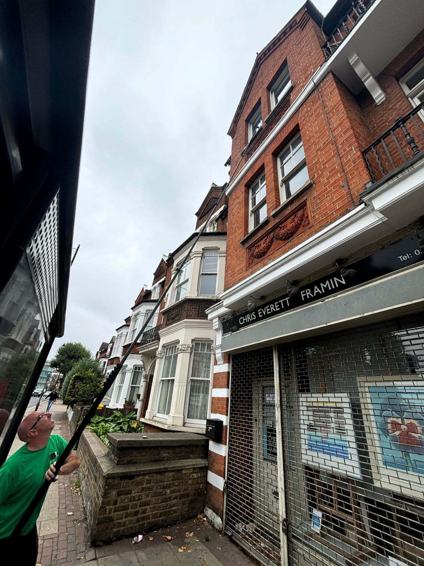 Window cleaner working on Victorian terraced houses with traditional architecture