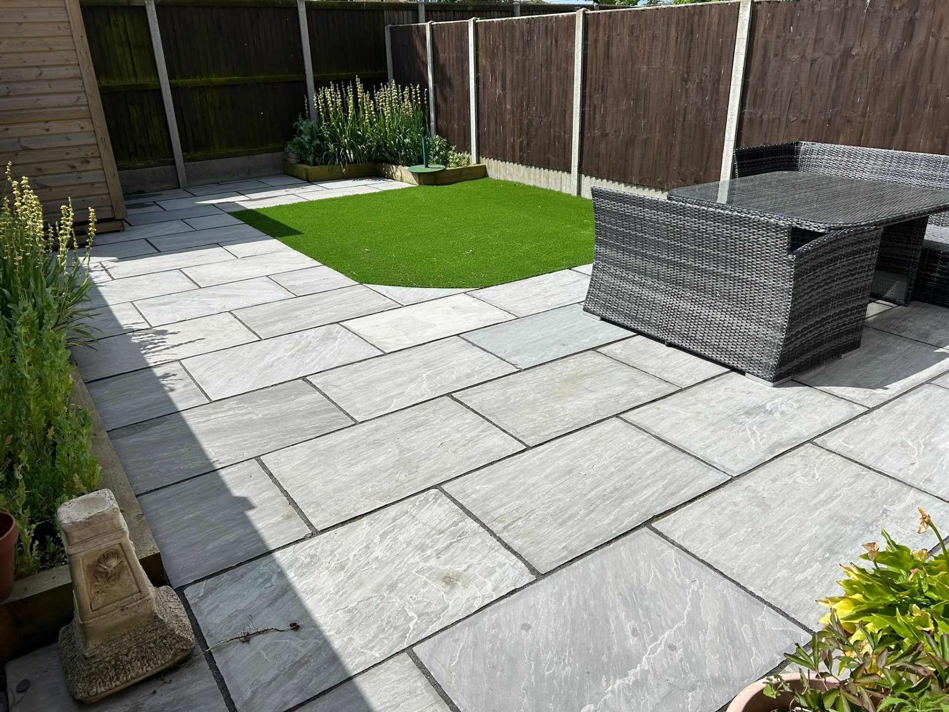 Professional patio cleaning results showing clean grey stone paving with outdoor furniture