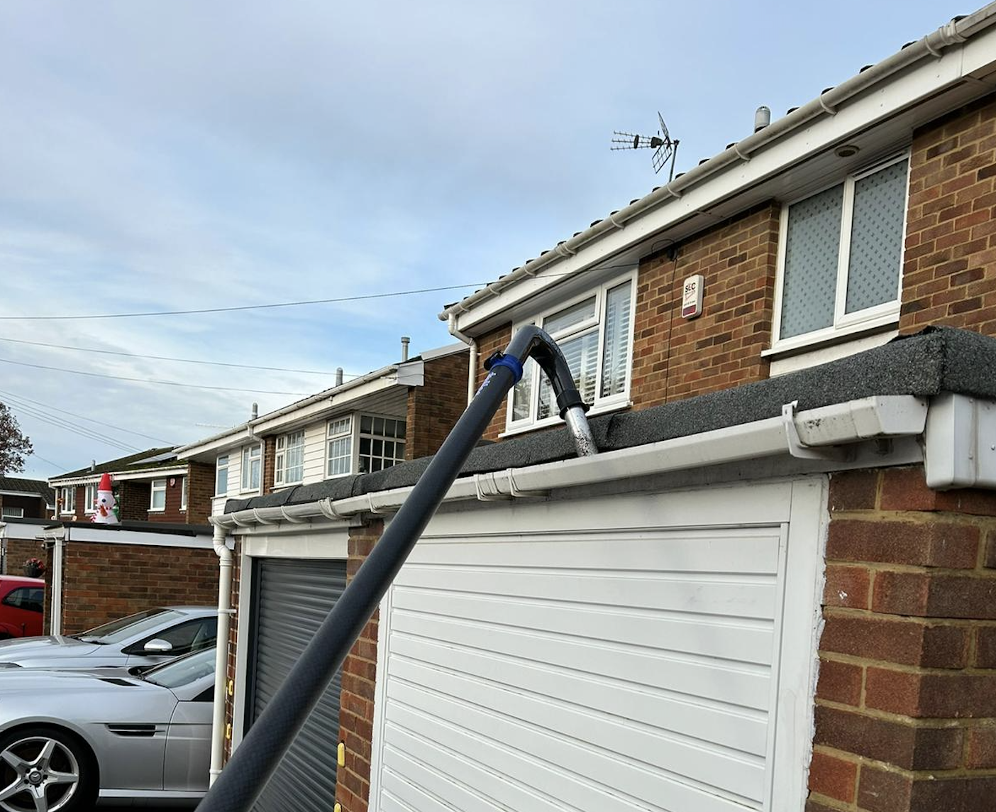 Gutter cleaning equipment clearing debris from residential guttering