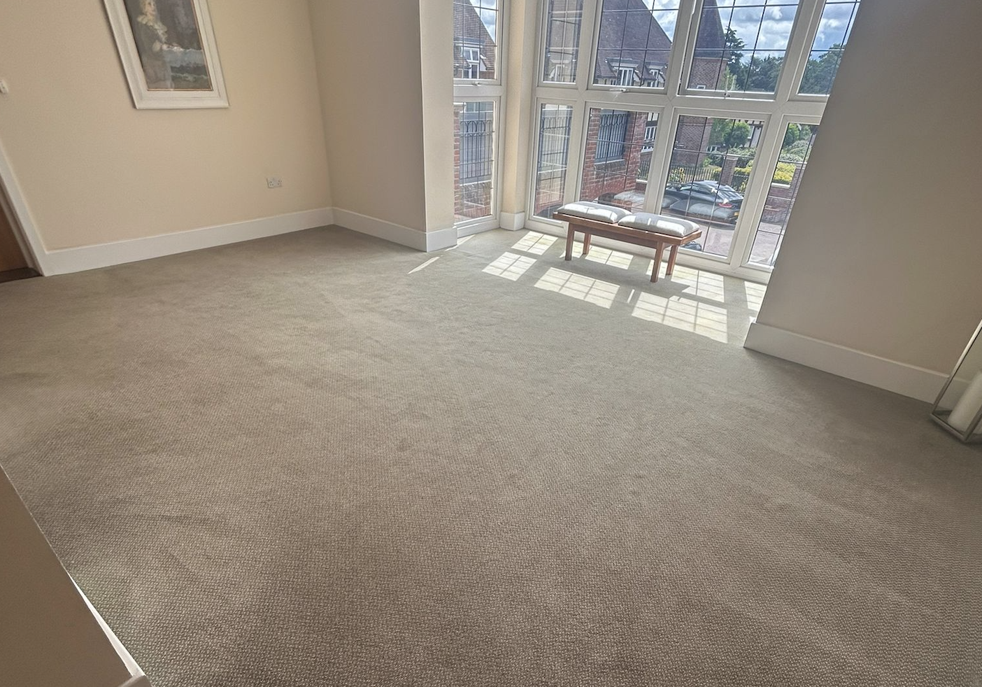 Immaculate communal room with professionally cleaned beige carpet, large bay windows and natural lighting